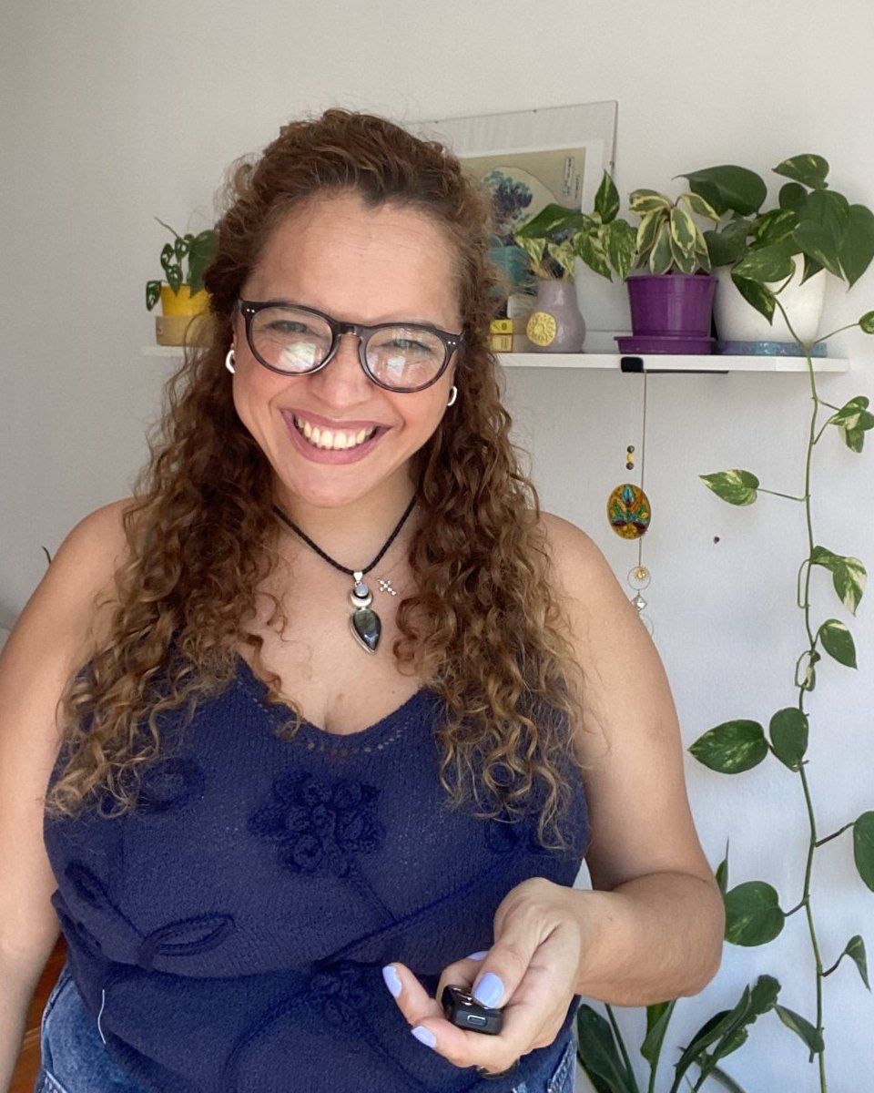 Aye Arrua sonriendo en su espacio, junto a sus plantas
